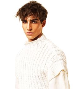 a young man with short hair wearing a white sweater