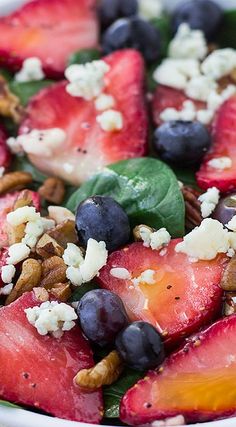 fruit salad with blueberries, strawberries, pecans and feta cheese on top