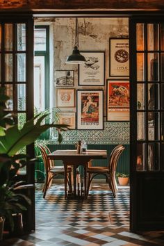 an open door leading to a dining room with posters on the wall and table in between