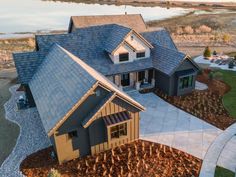 an aerial view of a house with a lake in the background