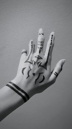 a person's hand with black and white tattoos on it