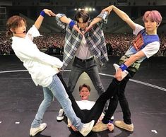 group of people standing on top of a stage with their arms in the air and one person holding his head