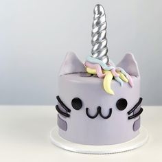 a cat cake with a unicorn horn on top