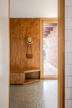 an open door leading to a room with a clock on the wall and a bench