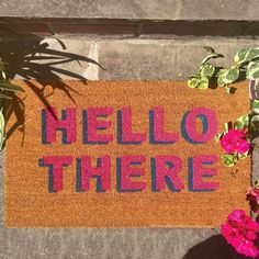 a welcome mat with the words hello there on it next to some potted plants