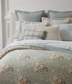 a bed with floral comforter and pillows on it