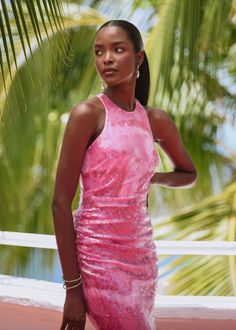 a woman in a pink dress posing for a photo