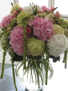 a vase filled with lots of pink and white flowers