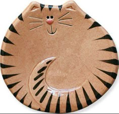 a ceramic cat sitting on top of a wooden plate