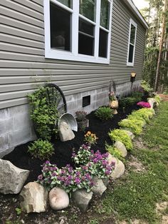 a house with flowers and rocks in the front yard