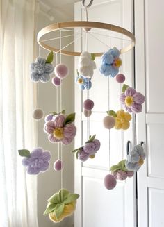 a mobile with flowers hanging from it's side