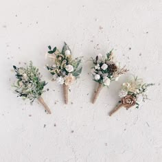 three bouquets of flowers are arranged in the shape of cones on a white surface