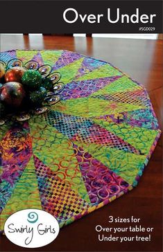 the cover of quilts over under magazine, featuring an image of a table with ornaments on it