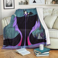 a blanket with an image of maleficent on it sitting next to a couch