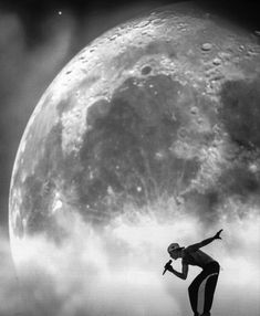 a man standing on top of a rock next to the moon