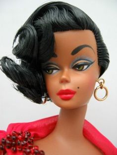 a close up of a doll wearing a red dress and large hoop earrings with black hair