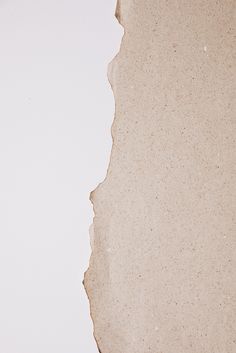 an old torn piece of paper sitting on top of a white table next to a clock