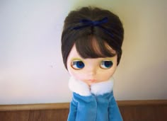 a doll wearing a blue coat and white collar