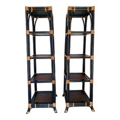 a pair of black and gold bamboo bookcases