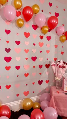 a room filled with lots of pink and red balloons