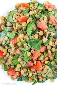 a white plate topped with spinach and tomatoes