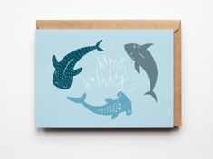 a card with two dolphins and the words happy birthday written on it in blue ink