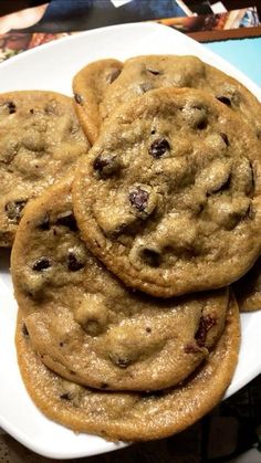 chocolate chip cookies are stacked on a white plate