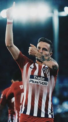 a soccer player is holding his hand up in the air and making a gesture with both hands