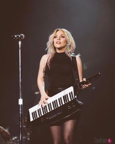 a woman in tights holding a keyboard on stage