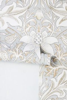 the wall paper is white and has gold designs on it, as well as silver trimmings