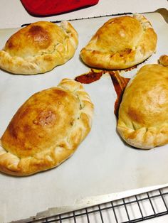 four baked pastries sitting on top of a baking sheet