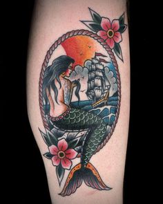 a mermaid with a ship in the background and flowers on her arm is shown here