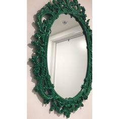 an ornate green mirror hanging on the wall