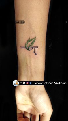 a person with a green leaf tattoo on their arm