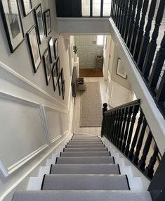 a staircase with pictures on the wall and carpet