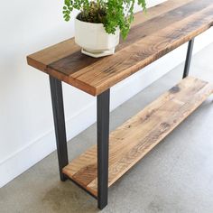 a potted plant sitting on top of a wooden table next to a metal frame