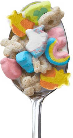 a spoon filled with marshmallows and other candy items on top of it