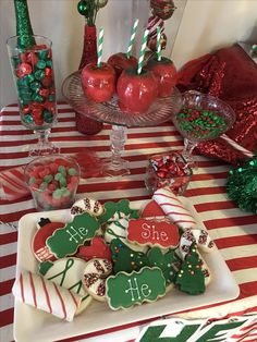 a table topped with lots of cookies and candies on top of a white plate