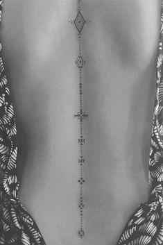 the back of a woman's body with an intricate design on it, in black and white