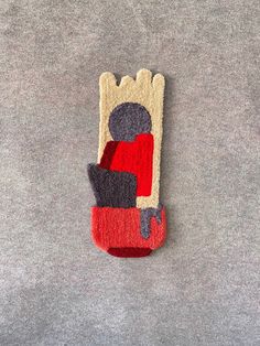 a piece of felt with an image of a person sitting in a chair on the floor