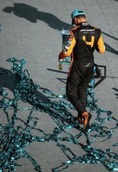 a man walking down a street next to a pile of blue confetti