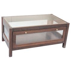 a wooden and glass coffee table with two drawers on one side, against a white background