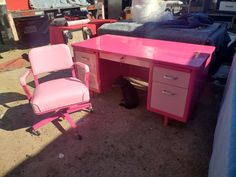 a pink desk with a cat sitting under it