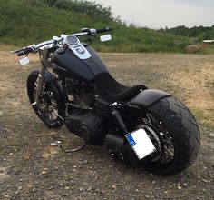 a black motorcycle parked on top of a gravel road