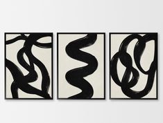 three black and white paintings hanging on the wall