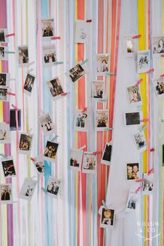 the wall is decorated with many different pictures and ribbons hanging from it's sides