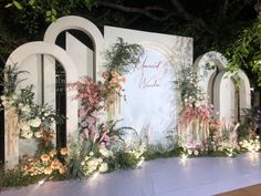 a decorated stage with flowers and greenery on it