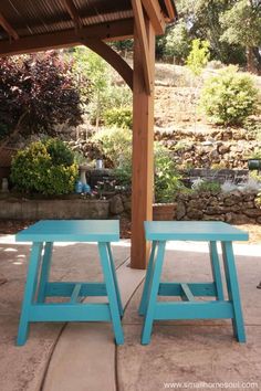 two blue stools sitting under a wooden structure