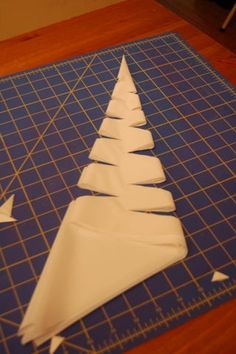 a paper christmas tree on a cutting board