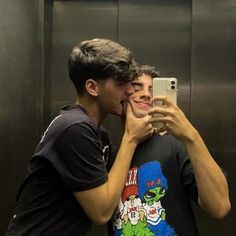 two young men taking pictures in an elevator